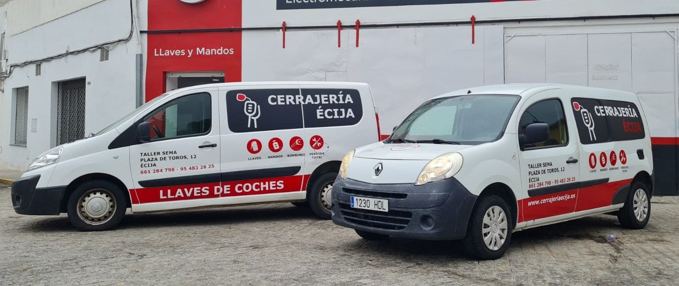 Las dos furgonetas de Cerrajería Écija aparcadas delante de la puerta de Taller Sema