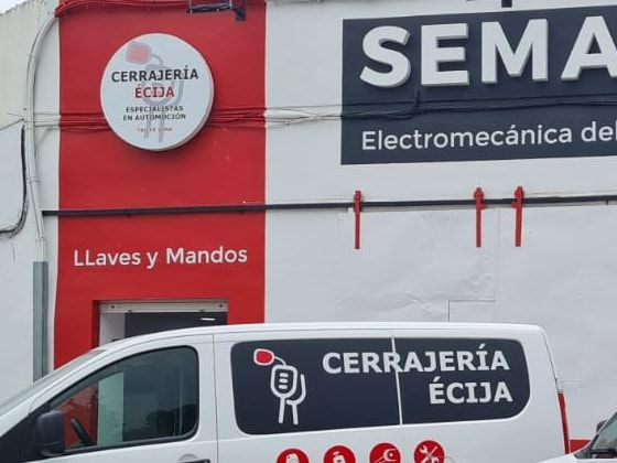 Lateral rojo del local con el rótulo de Cerrajería Écija y "Llaves y Mandos"