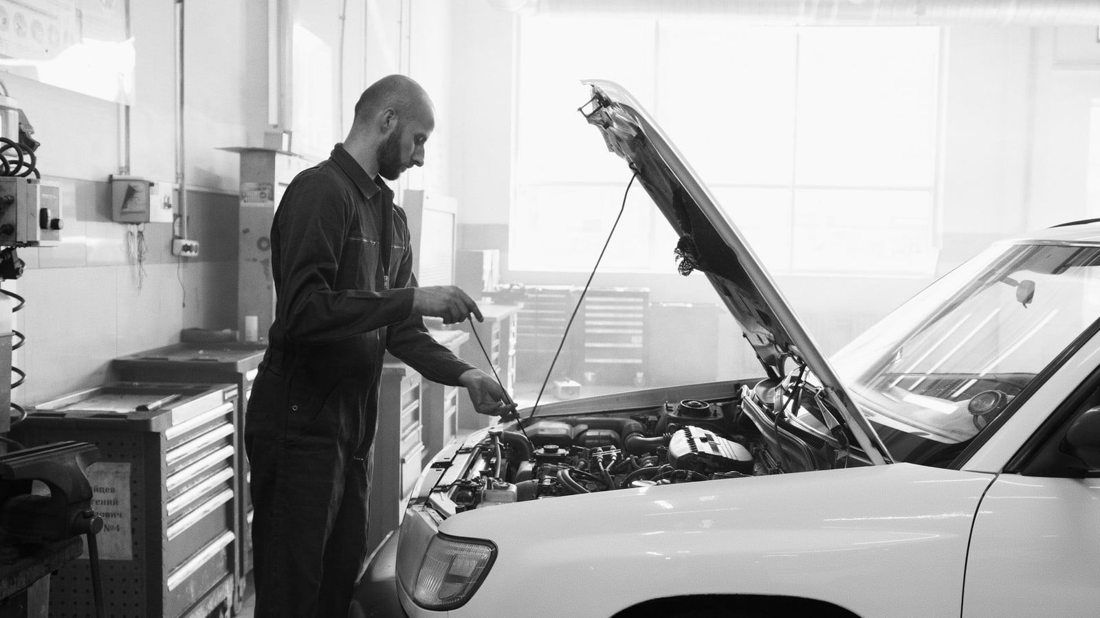 Mecánico revisando un coche con el capó abierto en el taller